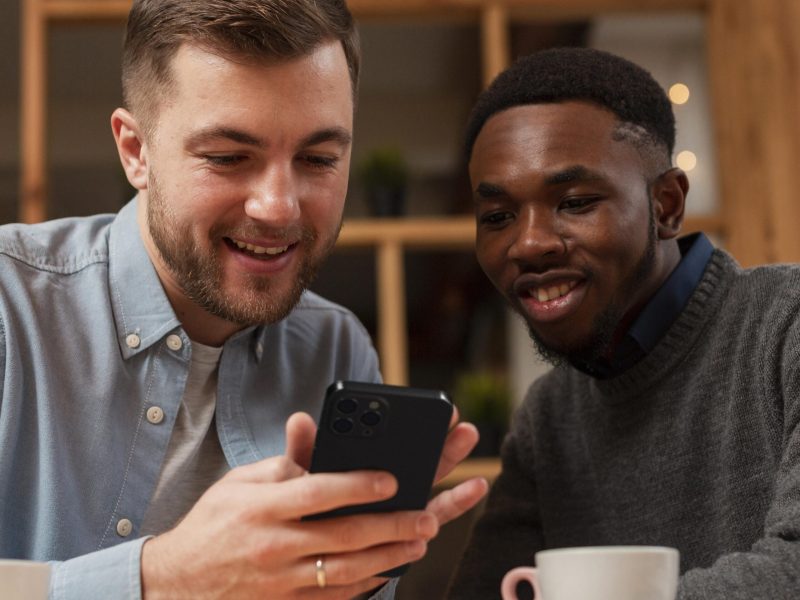 smiley-men-using-smartphone-cafe